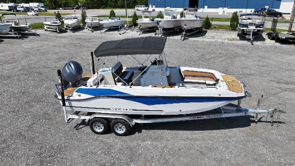 Starcraft SVX 211 OB CC 2024 Starcraft SVX 211 OB CC boat on trailer, parked in a lot with other boats.