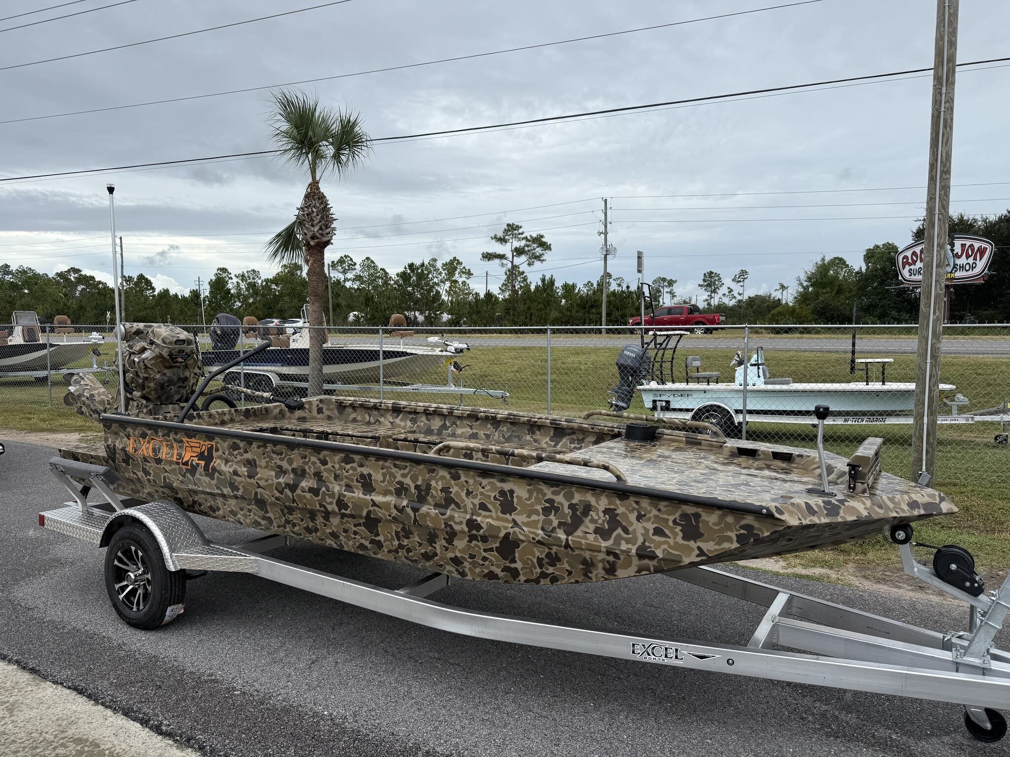 Excel Shallow Water F4 1754 2026 Excel Shallow Water F4 1754 boat with camouflage design on a trailer.