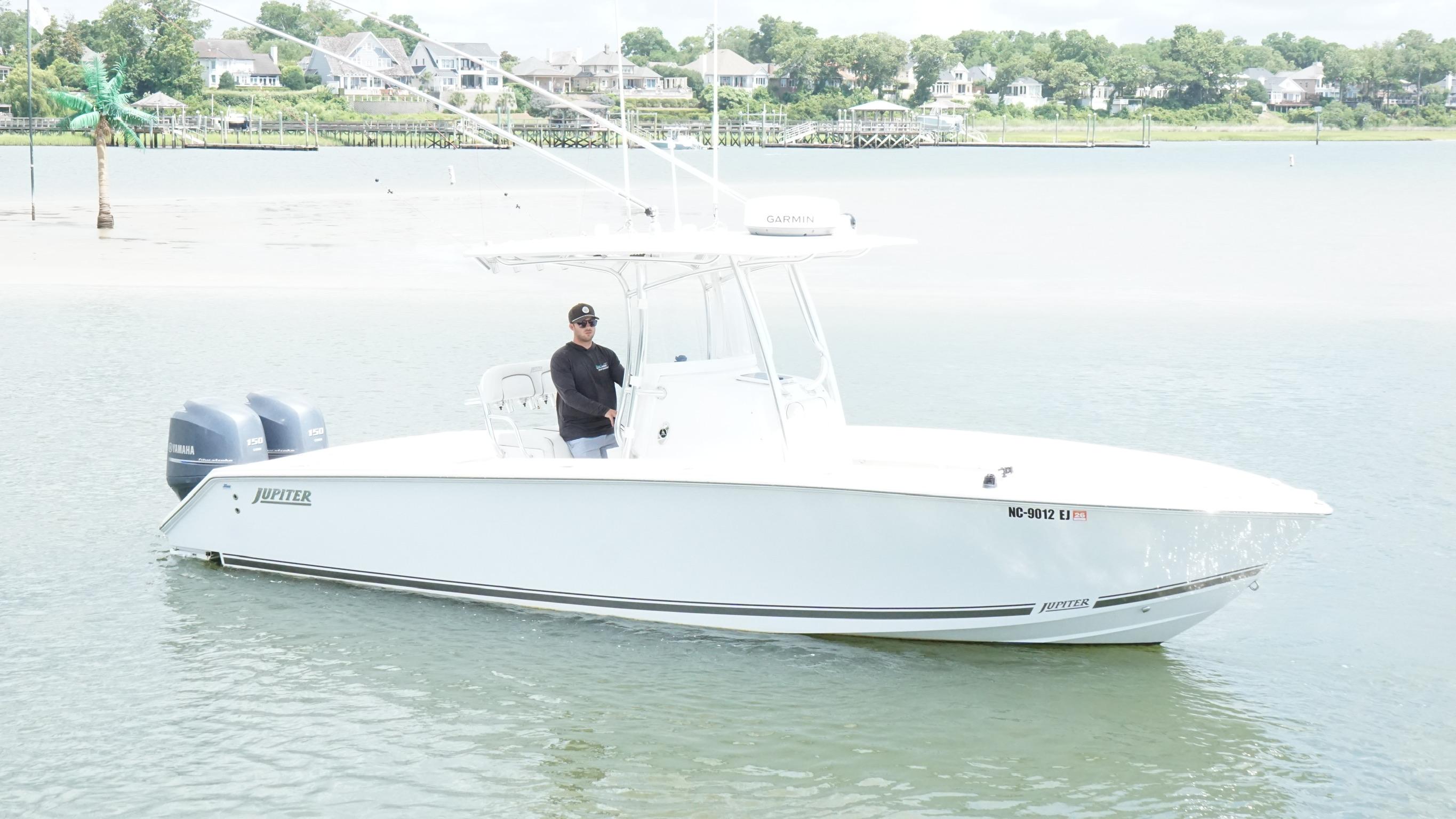Jupiter 26 A 2012 Jupiter 26 boat on calm water with a person onboard.