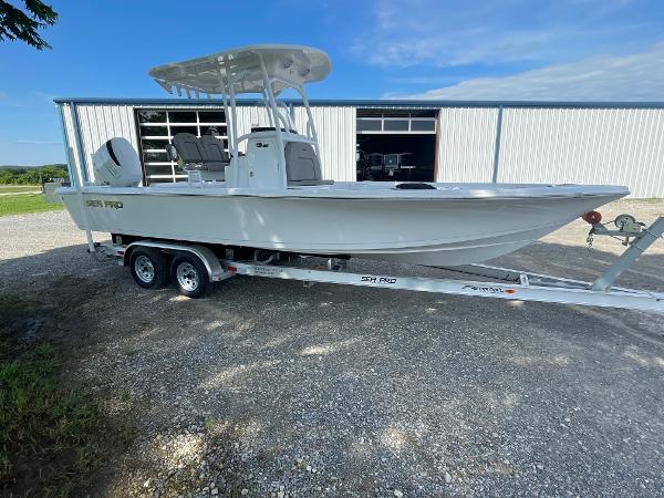 Sea Pro 250 Bay 2024 Sea Pro 250 Bay boat on a trailer outside a warehouse.