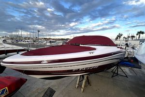 Tahoe Q4 SS 2009 Tahoe Q4 SS boat with maroon cover at marina, under a partly cloudy sky.