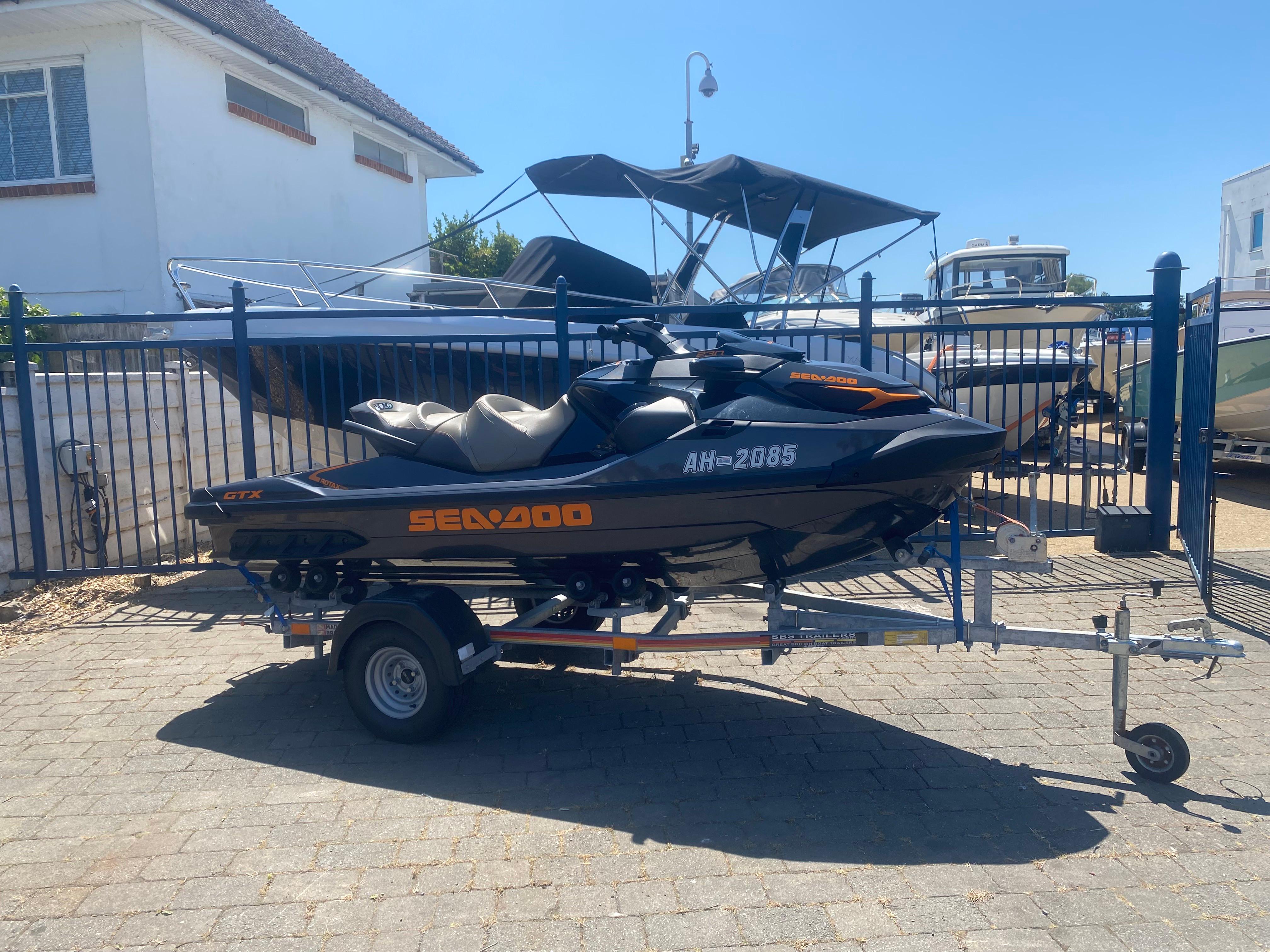 Sea-Doo GTX 230 2023 Sea-Doo GTX 230 jet ski on trailer, parked outdoors near boats.
