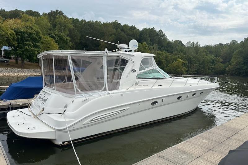 Sea Ray Sundancer 460 2003 Sea Ray Sundancer 460 yacht docked on a calm lake with lush greenery.