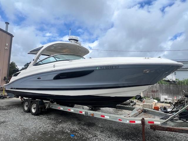 Sea Ray 350 SLX 2016 Sea Ray 350 SLX boat on trailer, under cloudy sky.