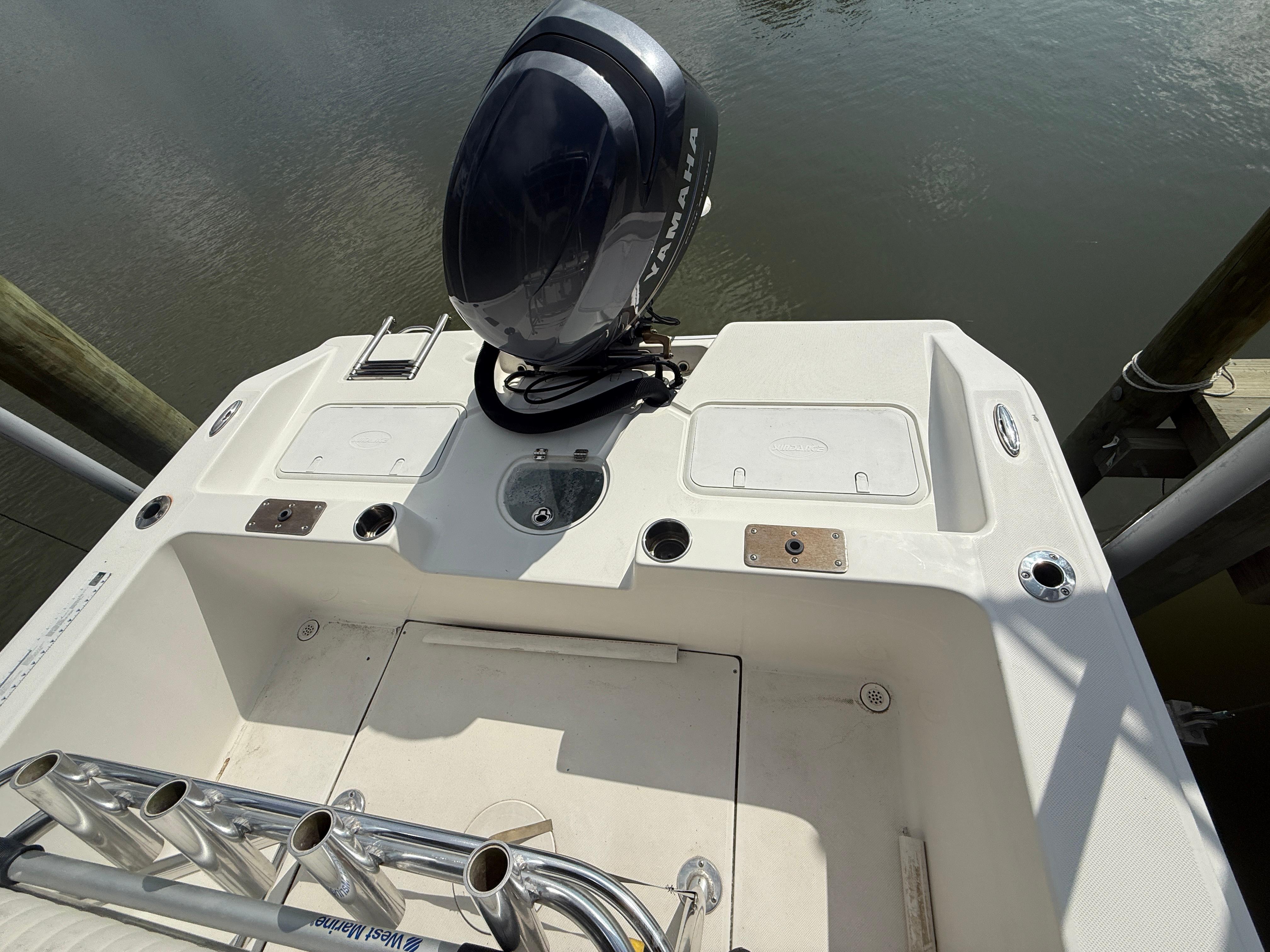 Sundance NX 21 2012 Sundance NX 21 boat with Yamaha outboard motor, docked on calm water.