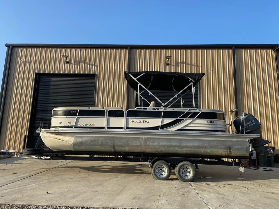 South Bay 522 RS 2013 South Bay 522 RS pontoon boat on trailer, parked outside a warehouse.