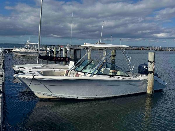 Cobia 240 Dual Console 2021 Cobia 240 Dual Console boat docked in a marina under cloudy skies.