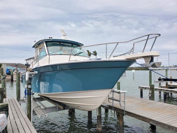 Grady-White Express 330 2018 Grady-White Express 330 boat docked at marina, blue hull, calm waters.