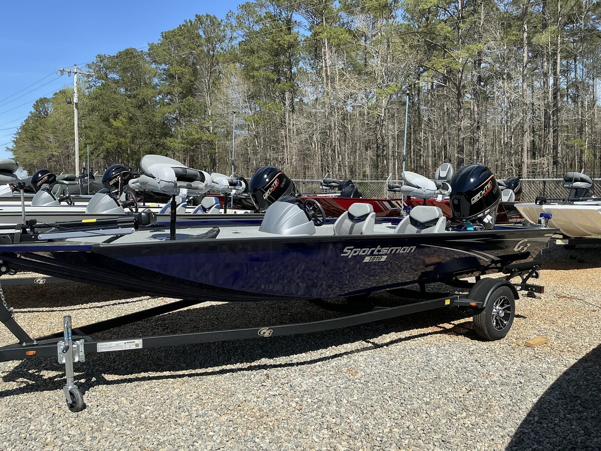 G3 Sportsman 1810 2025 G3 Sportsman 1810 boat on trailer, parked outdoors with trees in background.