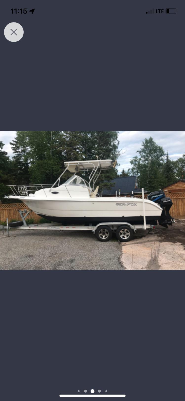 Sea Fox 230 Walk Around 2003 Sea Fox 230 Walk Around boat on trailer, parked outdoors.