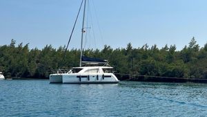 Leopard 40 2018 Leopard 40 catamaran anchored on calm water near a forested shoreline.