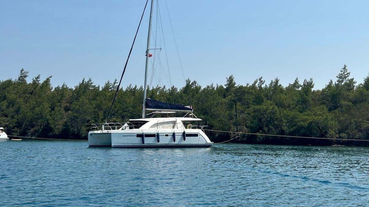 Leopard 40 2018 Leopard 40 catamaran anchored on calm water near a forested shoreline.