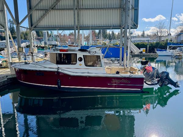 Ranger Tugs R-23 2017 Ranger Tugs R-23 boat docked in a marina, under a covered structure.