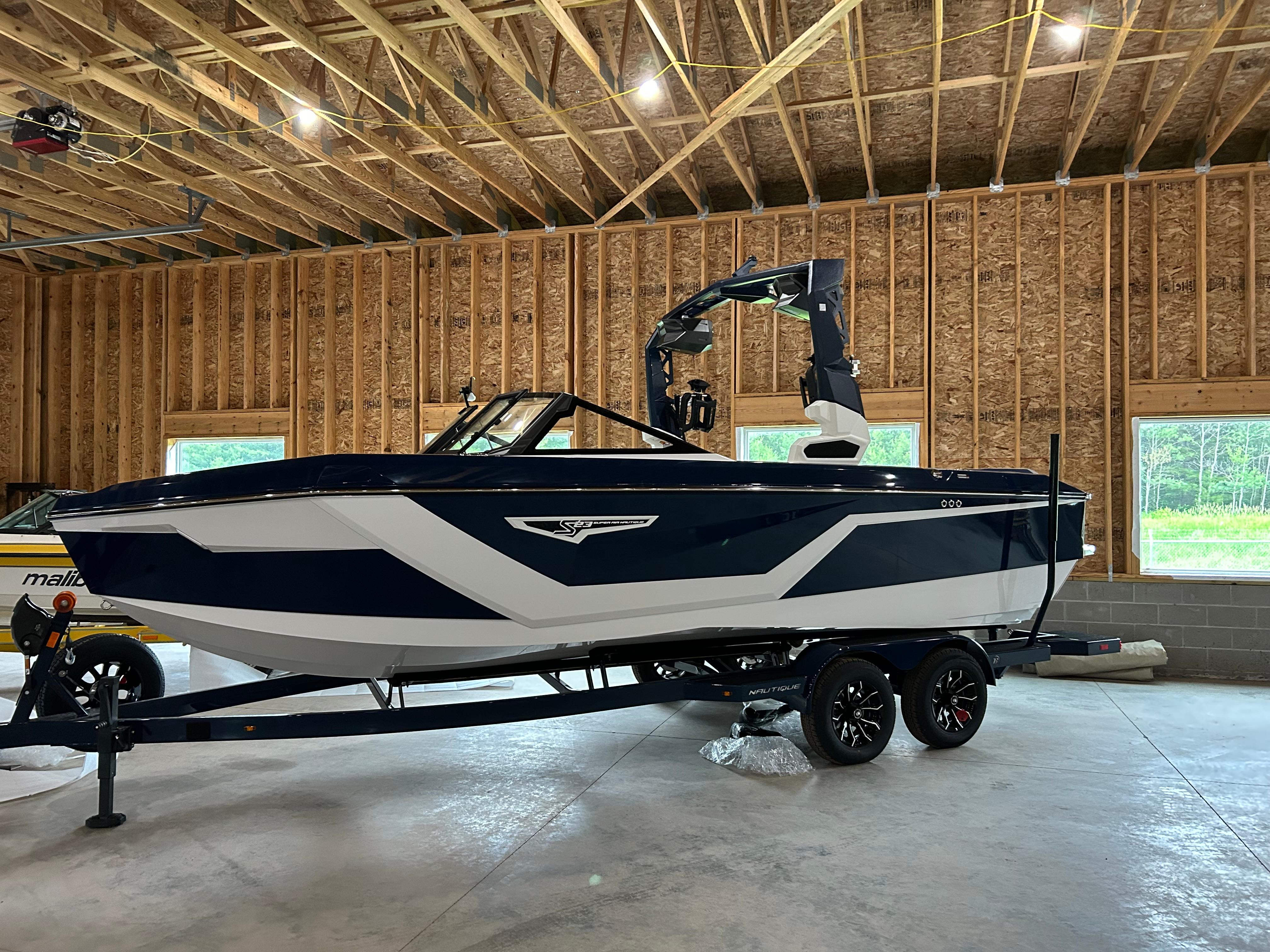 Nautique Super Air Nautique S23 2025 Nautique Super Air Nautique S23 boat in a wooden garage, on a trailer.