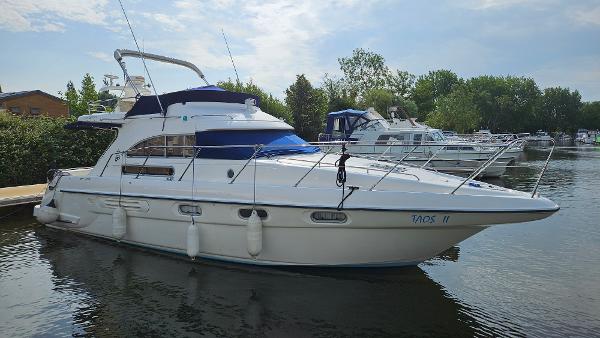 Sealine 360 Statesman 1995 Sealine 360 Statesman yacht docked on calm water, surrounded by trees and other boats.