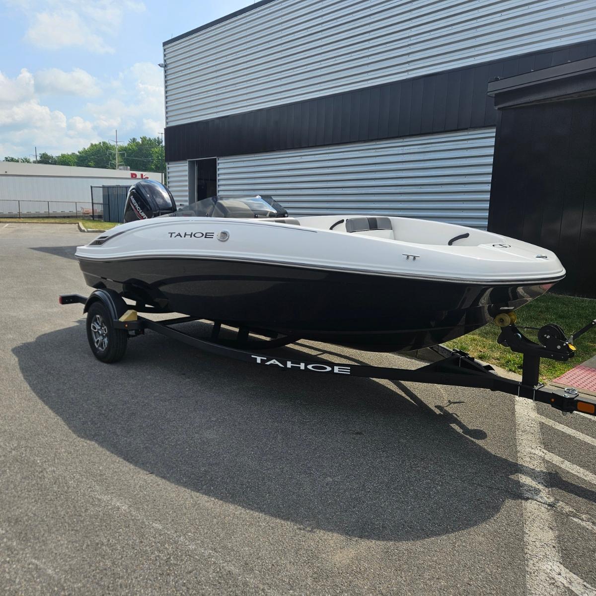Tahoe T16 2025 Tahoe T16 boat on trailer, parked outdoors near a building.
