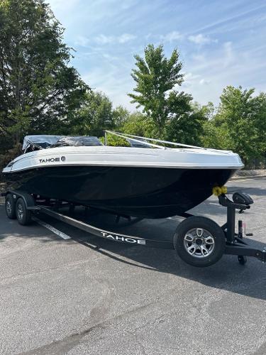 Tahoe T21 2025 Tahoe T21 boat on trailer, parked outdoors, surrounded by trees.
