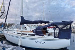 Catalina C-30 1982 Catalina C-30 sailboat docked at marina under cloudy sky.