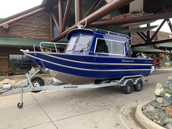 Spartan 220 Maximus Pro 2023 Spartan 220 Maximus Pro boat on Karavan trailer outside a rustic building.