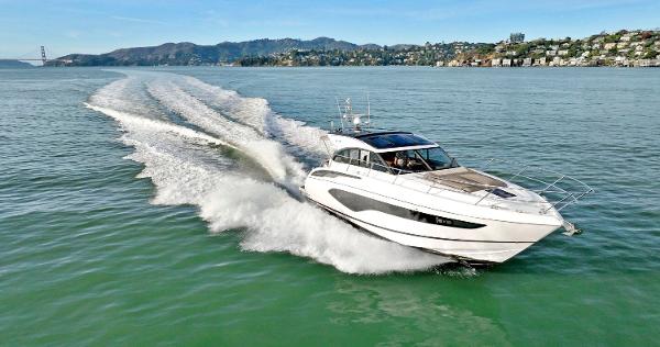 Princess V50 2019 Princess V50 yacht cruising on open water with scenic coastline backdrop.