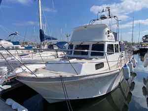 Corvette 320 2005 Corvette 320 boat docked in marina, surrounded by other vessels under a clear blue sky.