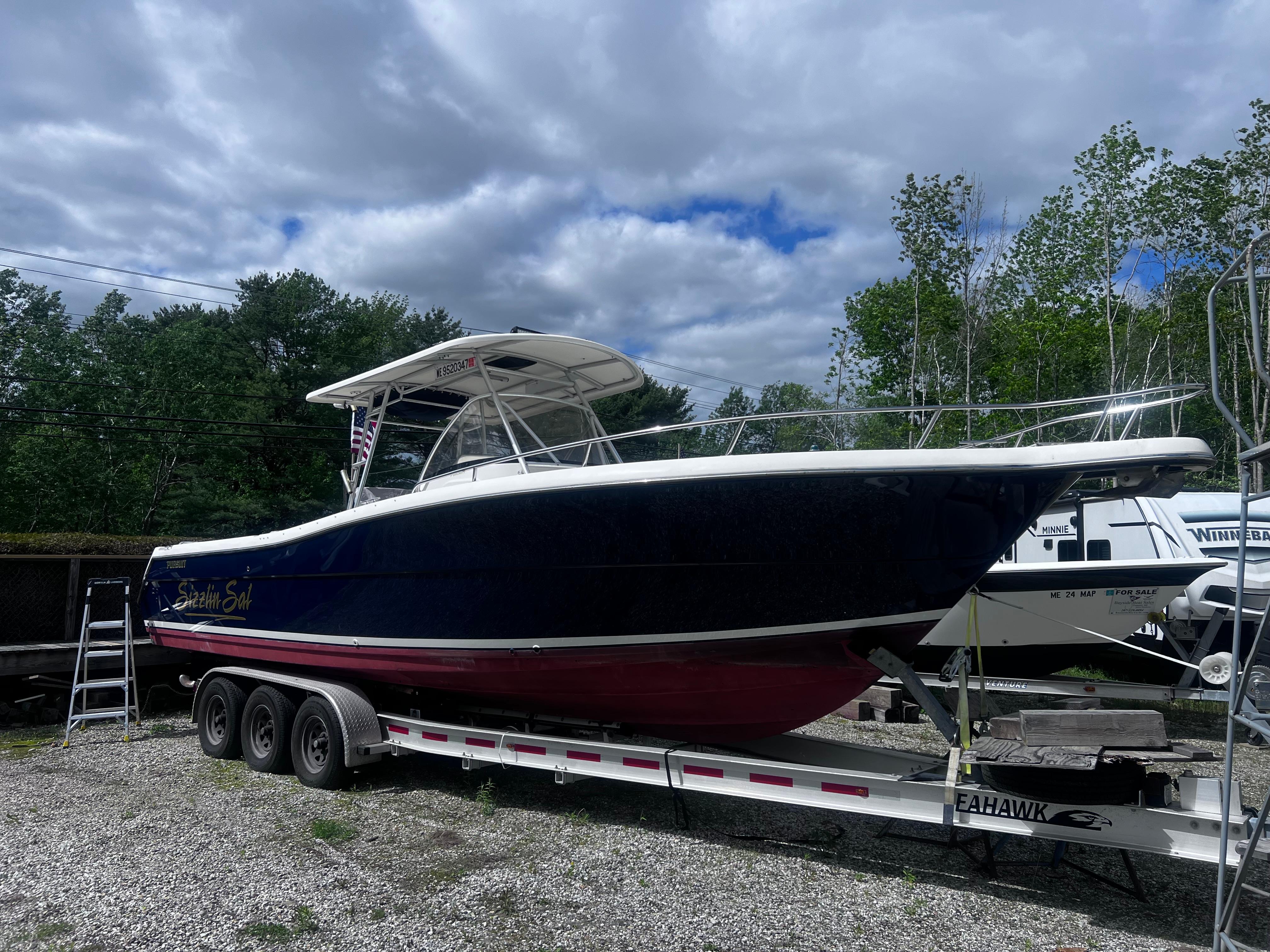 Pursuit 3070 Center Console 2001 Pursuit 3070 Center Console boat on trailer, parked outdoors under cloudy sky.