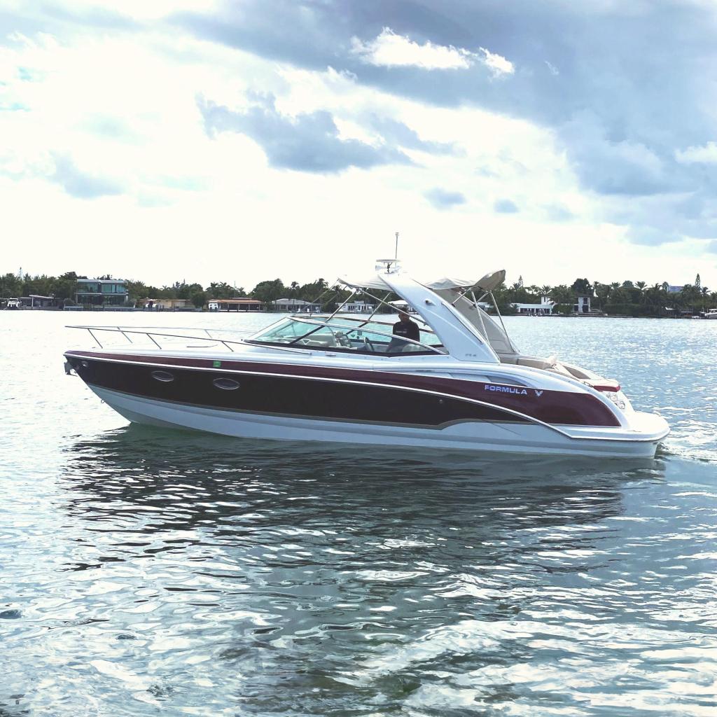 Formula 310 Sun Sport 2010 Formula 310 Sun Sport boat cruising on a calm water body under a cloudy sky.