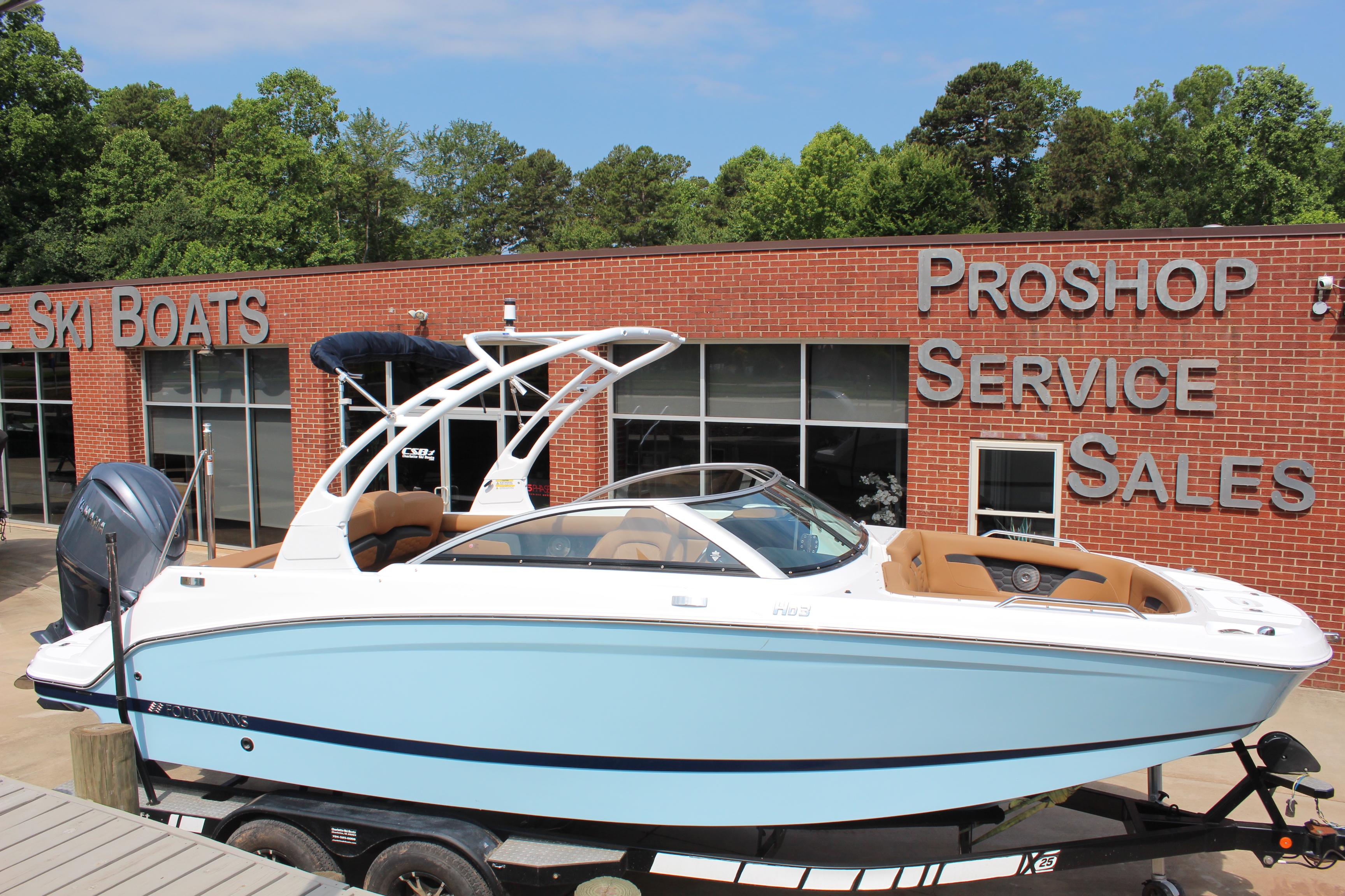 Four Winns HD3 OB 2025 Four Winns HD3 OB boat displayed at a dealership with service and sales signage.