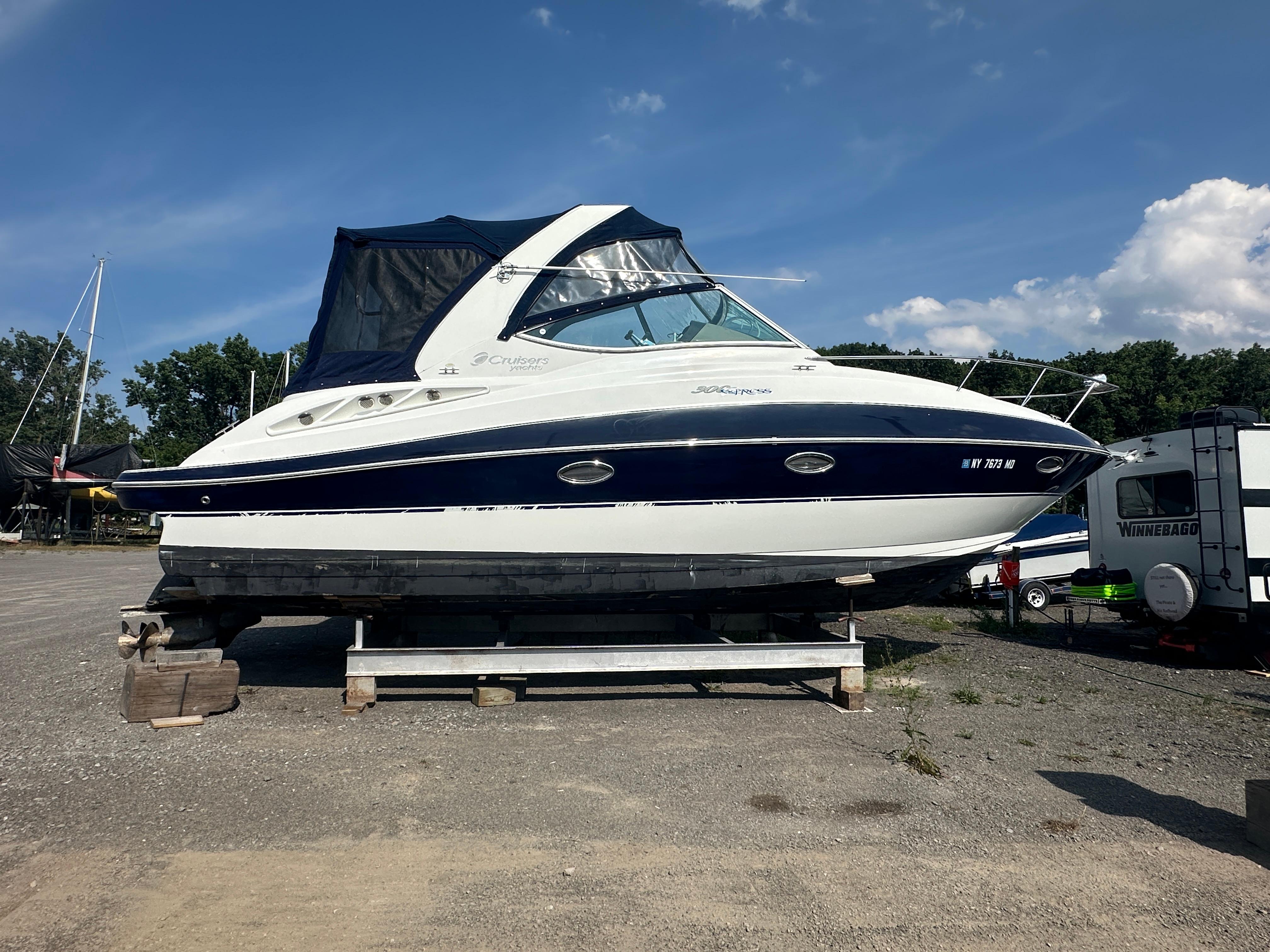Cruisers 300 Cxi 2009 Cruisers 300 CXi Express boat on dry dock under clear blue sky.