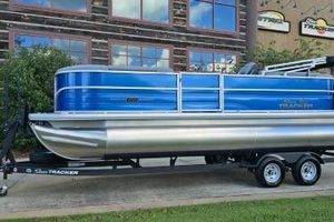 Sun Tracker Party Barge 22 DLX 2026 Sun Tracker Party Barge 22 DLX pontoon boat on trailer, parked outdoors.