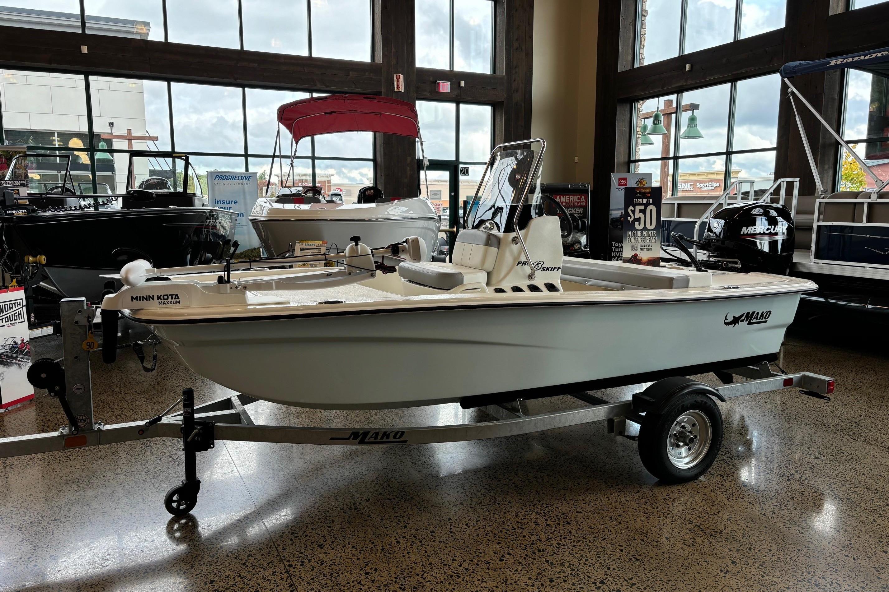 Mako Pro Skiff 13 CC 2025 Mako Pro Skiff 13 CC boat displayed indoors on a trailer.