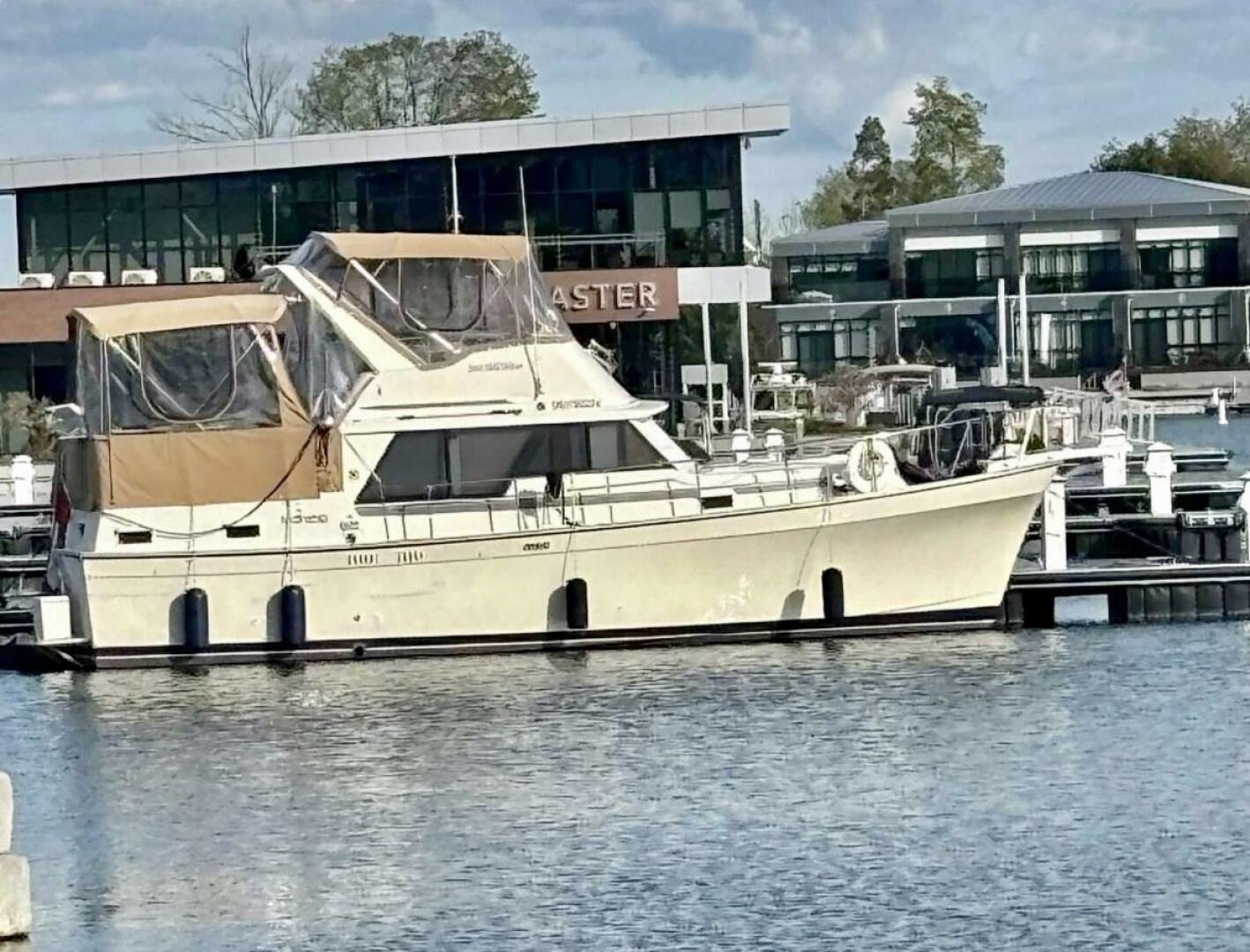 Mainship 36 Nantucket 1987 Mainship 36 NANTUCKET yacht docked at marina, modern buildings in background.