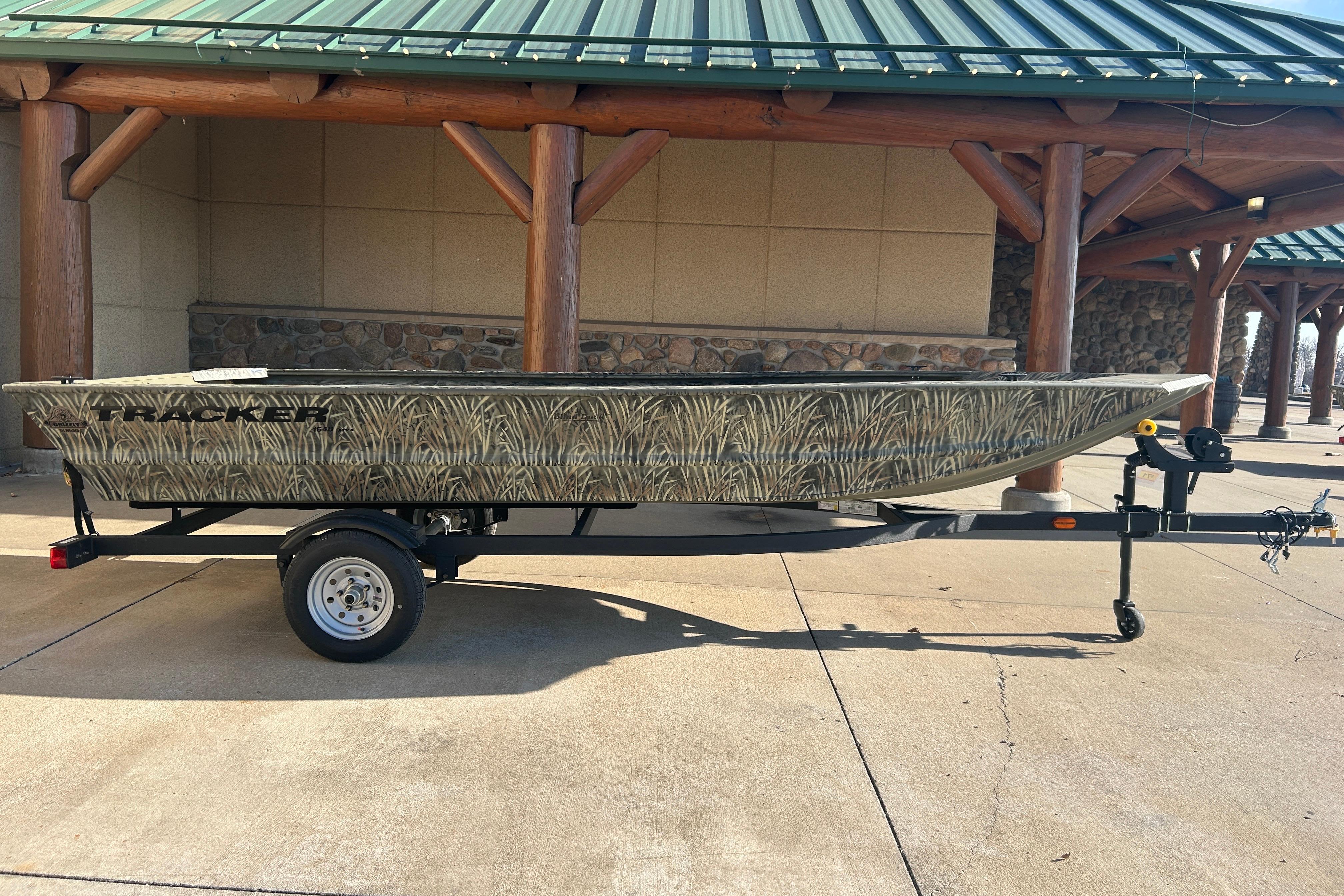 Tracker Grizzly 1648 Utility 2026 Tracker Grizzly 1648 Utility boat with camouflage design on a trailer.