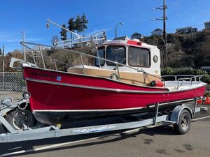 Ranger Tugs R21-EC 2010 Ranger Tugs R21-EC boat on trailer, red hull, parked outdoors.