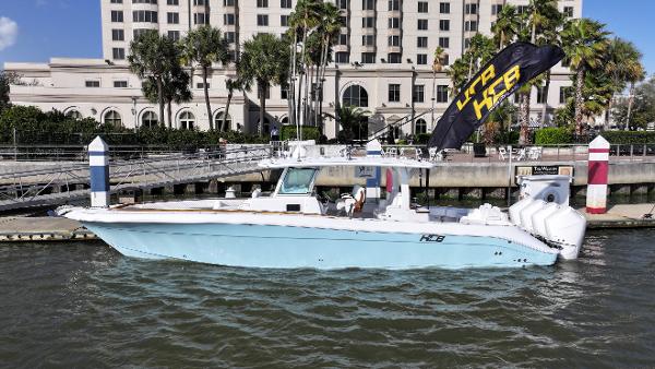 HCB Lujo 2025 HCB Lujo boat docked by a waterfront building with palm trees.