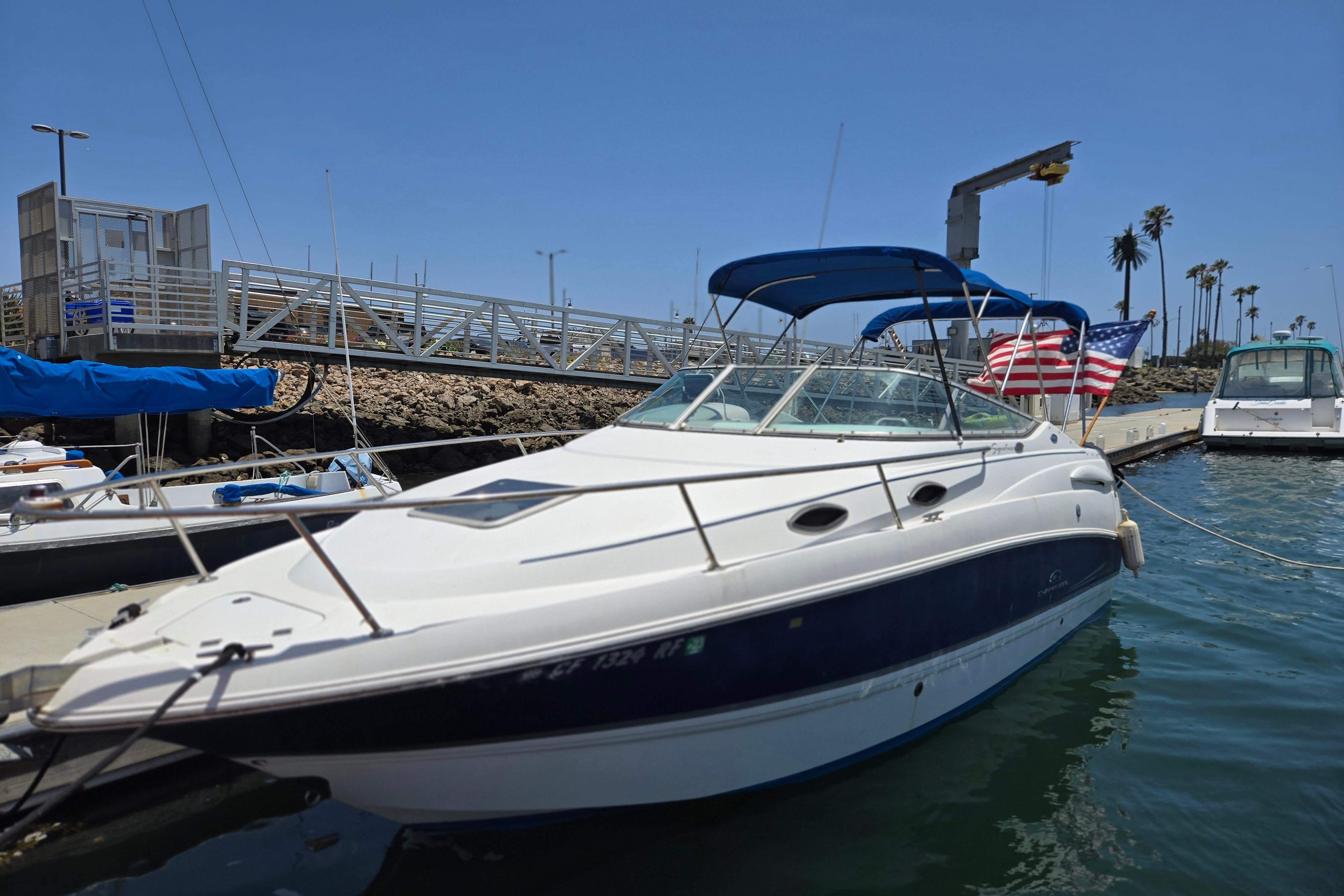 Chaparral Signature 240 2004 Chaparral Signature 240 boat docked with American flag, blue canopy, and clear sky.