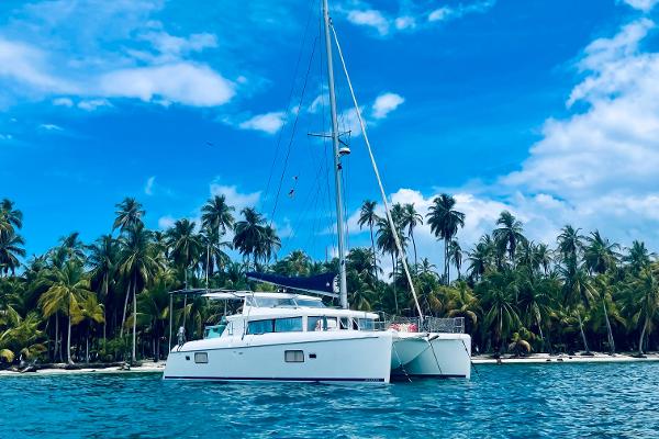 Lagoon 420 2008 Lagoon 420 Hybrid catamaran anchored near tropical palm-lined shore.