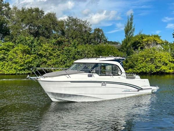 Beneteau Antares 8 2023 Beneteau Antares 8 boat cruising on a serene river with lush greenery.