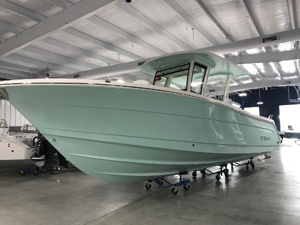 Robalo R302 2024 Robalo R302 boat in a showroom, mint green hull, side view.