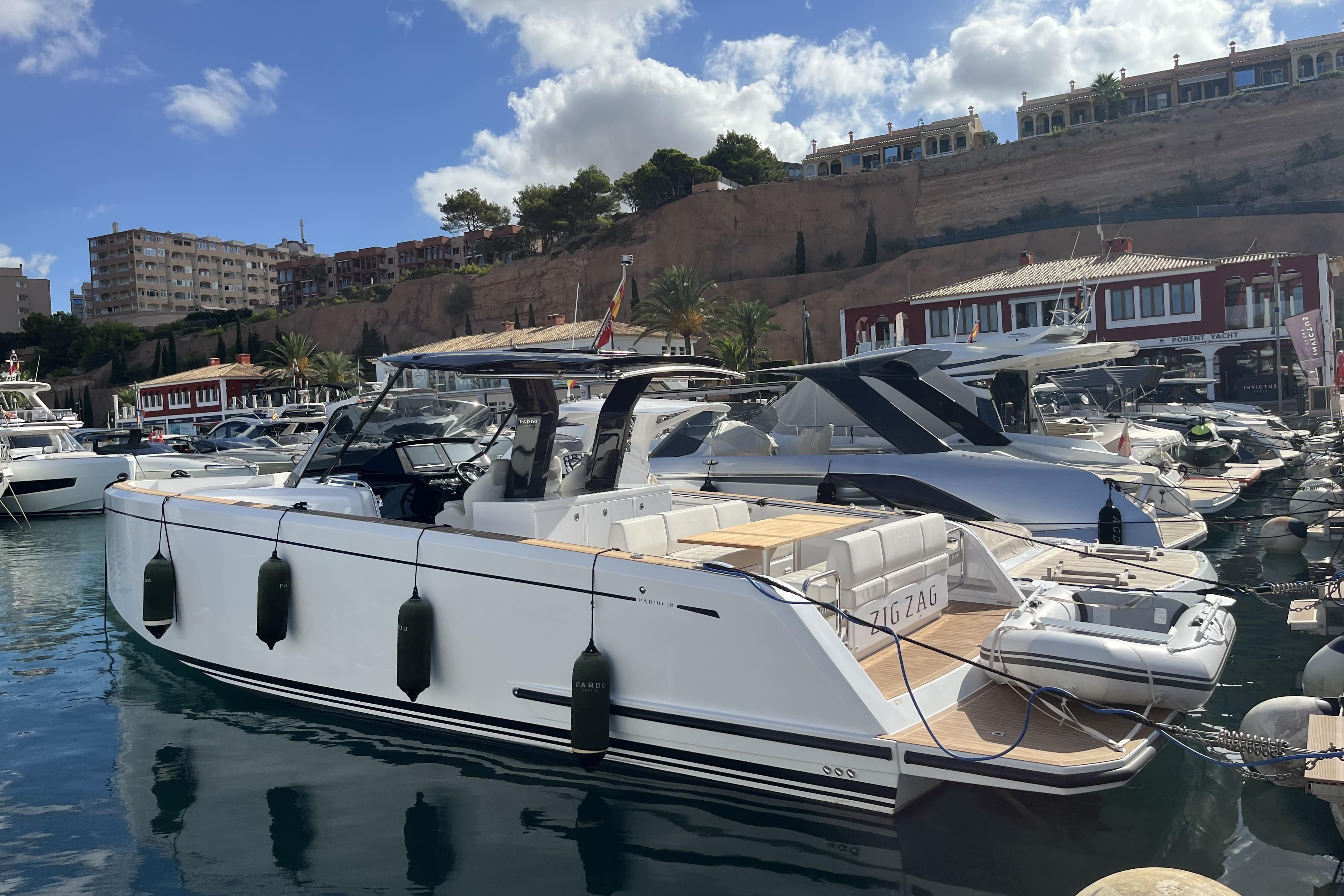 Pardo Yachts 38 2023 Pardo Yachts 38 docked in a marina, surrounded by other boats.