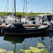 Lifestyle 740 Boat docked in marina with other sailboats, clear sky, and calm water reflections.