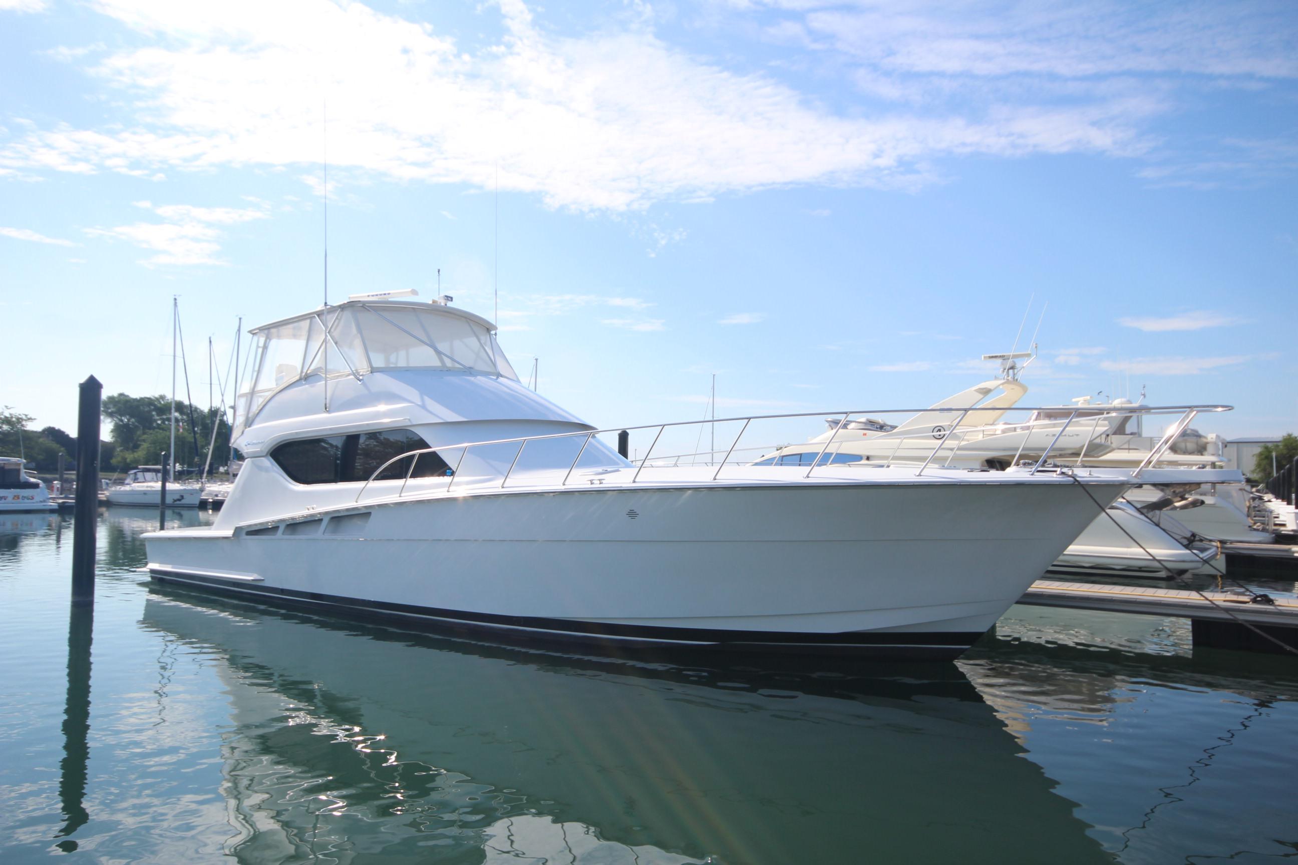 Hatteras 60 Convertible 2000 Hatteras 60 Convertible yacht docked in a marina under a clear blue sky.