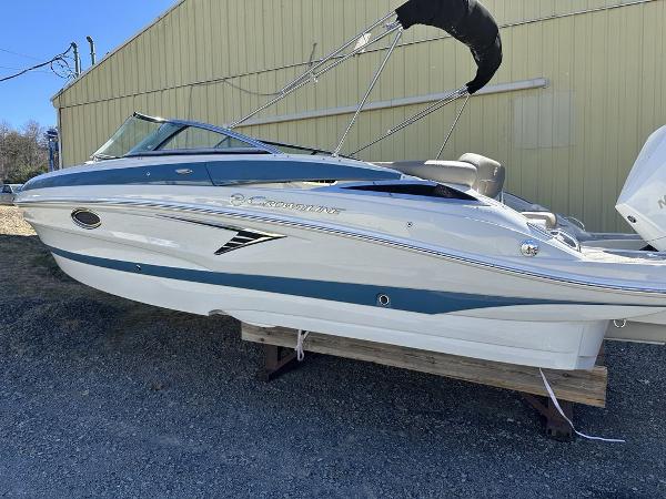 Crownline 250XSS 2024 Crownline XSS Series 250 boat on display outside a yellow building.