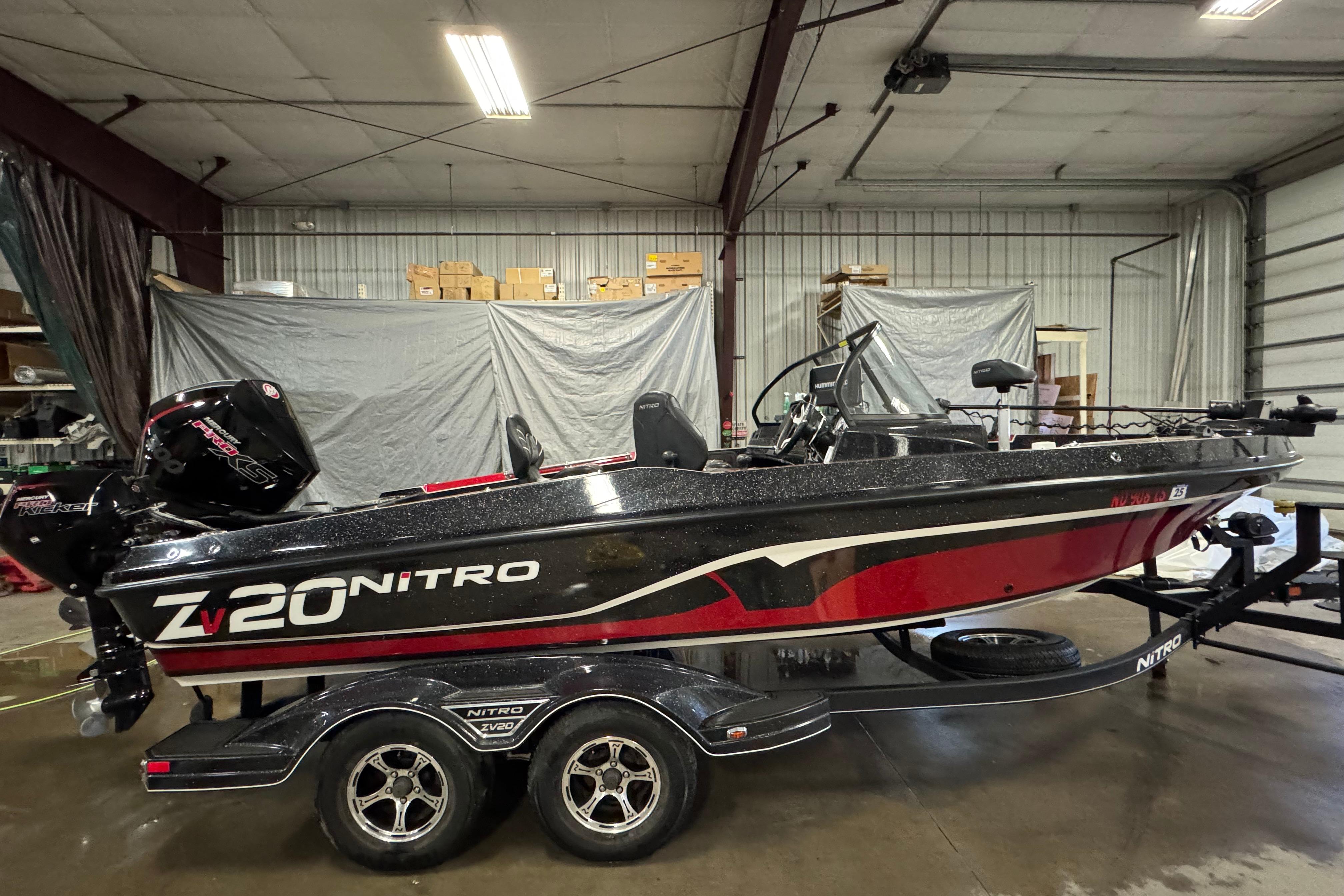 Nitro ZV20 2022 Nitro ZV20 boat in a garage, featuring sleek black and red design.