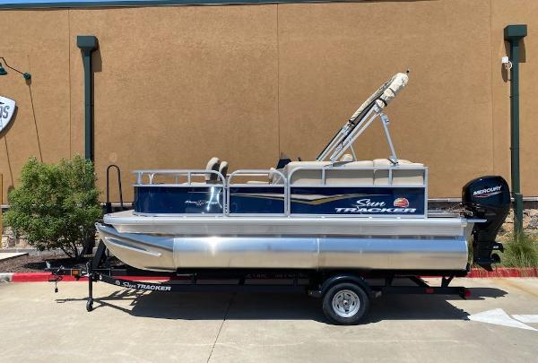 Sun Tracker Bass Buggy 16 XL Select 2025 Sun Tracker Bass Buggy 16 XL Select pontoon boat on trailer, parked outdoors.