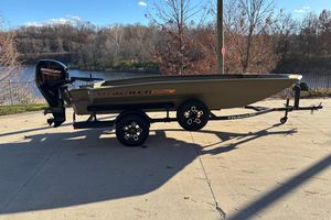 Tracker Grizzly 1756 T Marsh 2026 Tracker Grizzly 1756 T Marsh boat on trailer, parked near a scenic lake.