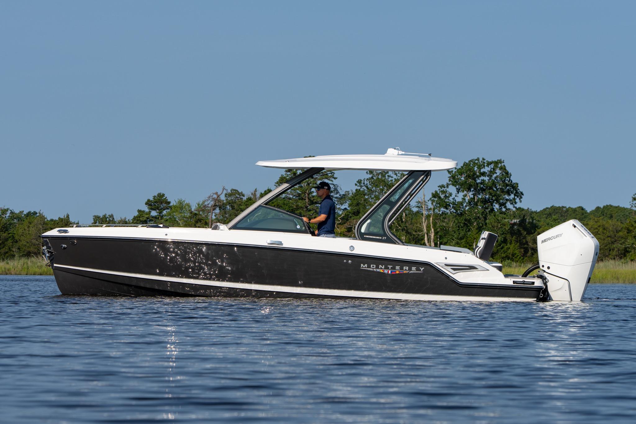 Monterey Elite 27 OB 2026 Monterey Elite 27 OB boat cruising on a calm lake with trees in the background.