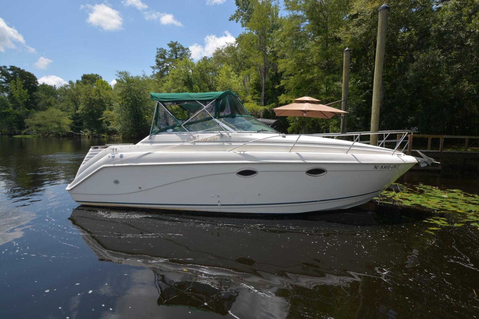 Rinker 270 Fiesta Vee w/Genset 1999 Rinker 270 Fiesta Vee boat on calm water, surrounded by lush greenery.