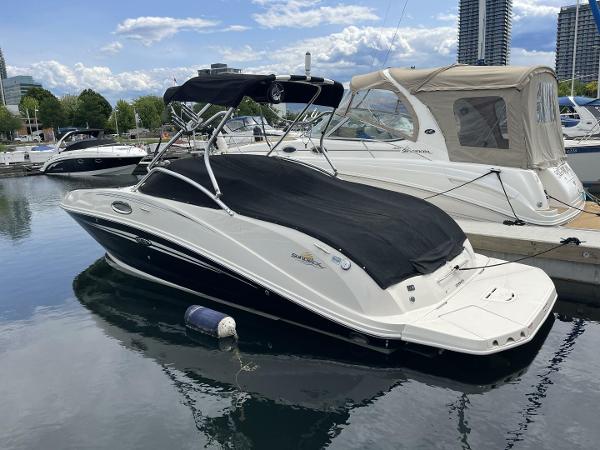 Sea Ray 260 Sundeck 2007 Sea Ray 260 Sundeck boat docked in a marina with cityscape background.