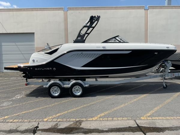 Bayliner D22I 2025 Bayliner D22I boat on trailer, sleek black and white design, parked outdoors.